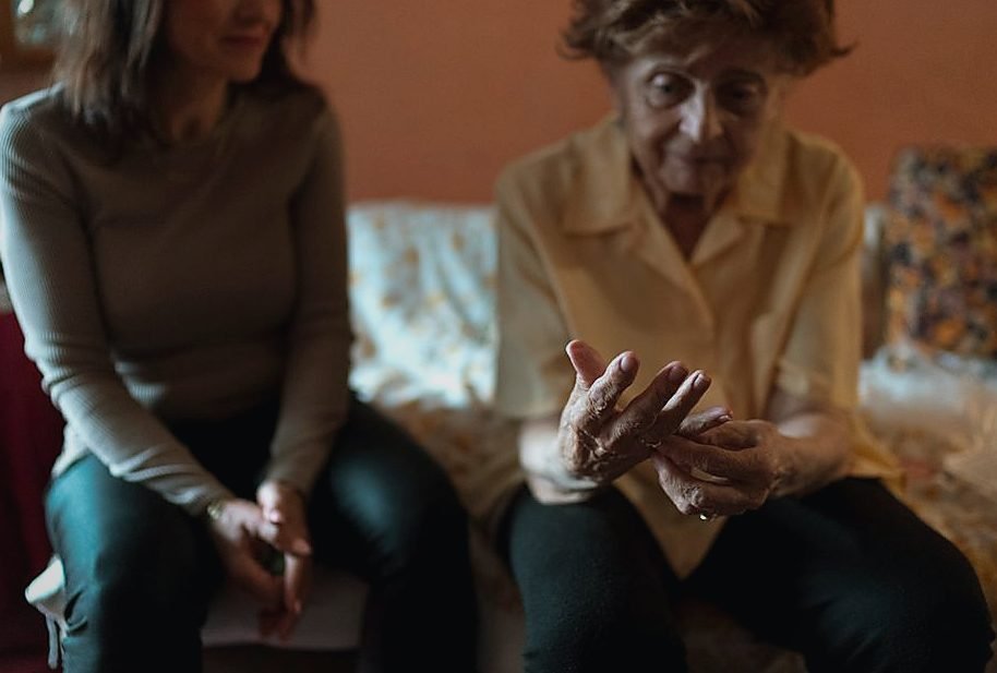 An elderly woman and her caregiver share a moment on the couch, embodying companionship — legat de azil seniori An elderly woman and her caregiver share a moment on the couch, embodying companionship — legat de azil seniori