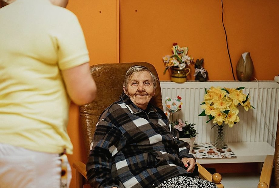 A warm scene of a senior woman sitting in an armchair at a retirement home with a caretake — legat de azil seniori A warm scene of a senior woman sitting in an armchair at a retirement home with a caretake — legat de azil seniori